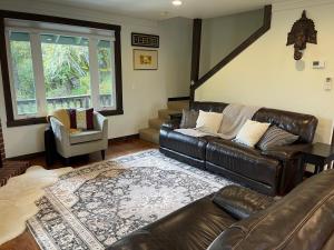 a living room with a leather couch and a chair at Avenue of the Giants River View Home (#1) in Miranda +48 photos
