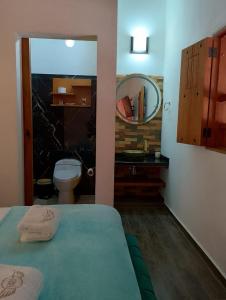 a bathroom with a bed and a toilet and a mirror at Casa Iris Hotel Boutique in Barichara