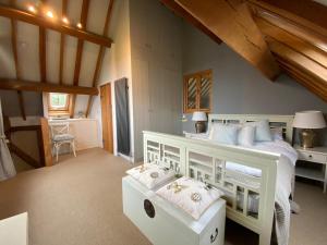 a bedroom with a white bed and a staircase at Beautiful country barn with hot tub and amazing views in Princes Risborough