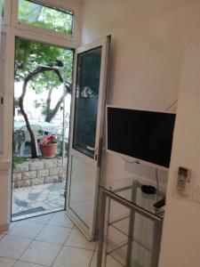 a sliding glass door with a television in a room at Apartments by the sea Pag - 21962 in Pag
