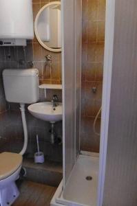 a small bathroom with a toilet and a sink at Apartments by the sea Pag - 21962 in Pag +17 photos
