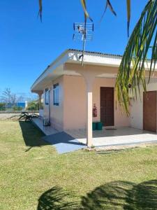 a small house with a grassy yard in front of it at Vaiana Home 2 - bord de lagon in Taputapuapea