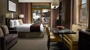 a hotel room with a bed and a table and a couch at Spring Break! Luxurious Ski-In · Ski-Out Resort! in Truckee