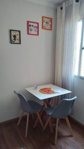 een witte tafel en stoelen in een kamer met een raam bij Apartamento Viracopos Campinas in Viracopos