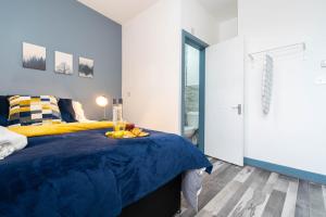 a bedroom with a blue bed with a tray of fruit on it at Sky rooms modern studio apartment 2 in Birmingham