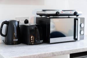 a toaster and a microwave on a kitchen counter at Sky rooms modern studio apartment 2 in Birmingham
