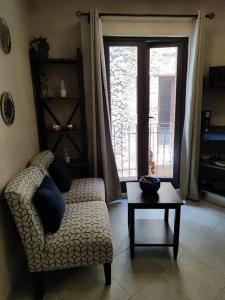 un soggiorno con divano, tavolo e finestra di Loft AMORE en Val'Quirico a Santeagueda
