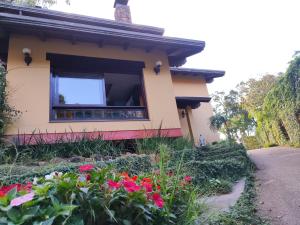 a house with a window and flowers at Pousada Oscar Magic Gramado in Gramado