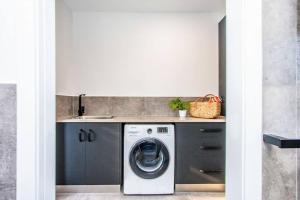 a kitchen with a washing machine and a sink at Malie - Holiday studio apartment in Agnes Water in Agnes Water