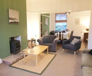 a living room with a couch and a fireplace at Beach House, Llanddulas near Colwyn Bay in Llanddulas