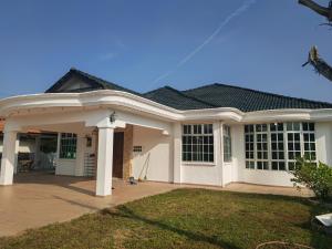 a large white house with a roof at Padang Serai Cozy Roomstay Share Bathroom in Padang Serai