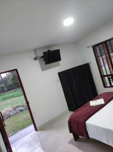 1 dormitorio con 1 cama y TV en la pared en Hospedaje villa luz en Pitalito