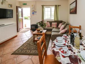 a living room with a couch and a table at Kingfisher Cottage in North Molton