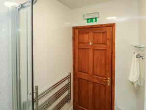 a bathroom with a wooden door in a room at Kingfisher Cottage in North Molton +22 photos