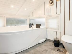 Fårvangにある6 person holiday home in Ebeltoftのバスルーム(白いバスタブ、トイレ付)