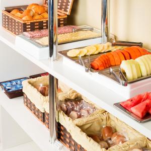 a display cabinet filled with different types of food at WR Confort Hotel Campo Grande in Campo Grande
