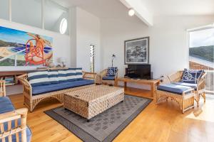 ein Wohnzimmer mit Sofas und einem TV in der Unterkunft Blue Pacific in Blueys Beach