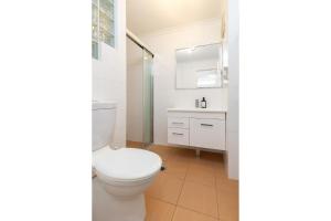 Un baño blanco con inodoro y lavabo. en Blue Pacific, en Blueys Beach 13 fotos más