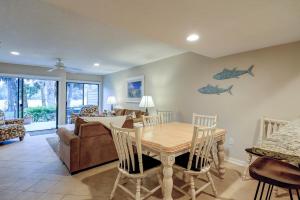 Un comedor con una mesa y un sofá. en Updated luxury two bedroom The Greens Condo New Baths walk in shower Nice Kitchen Golf Views, en Hilton Head Island