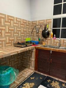 a kitchen with a wooden counter and a sink at Rerama Homestay Langkawi 5 minutes driving to Chenang Beach, kitchen, Wifi, parking, village vibes in Pantai Cenang