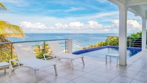een balkon met stoelen en uitzicht op de oceaan bij Villa Twin Palms 3 bedrooms in Dawn Beach