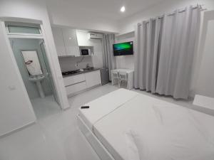 a white room with a bed and a bathroom at Apto T0 na Capital in Praia