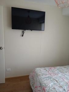 a bedroom with a bed and a flat screen tv on the wall at Dna 44 in Lima