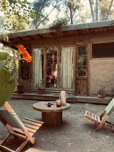 een patio met een tafel en stoelen en een huis bij Tierra Fértil Eco Posada in Santa Ana