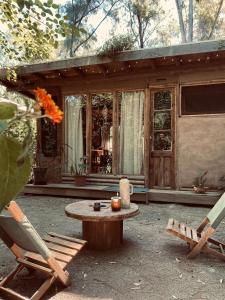 a patio with a table and chairs and a house at Tierra Fértil Eco Posada in Santa Ana