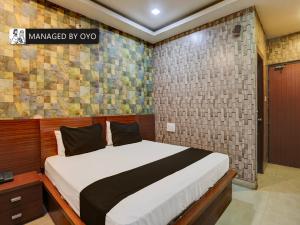 a bedroom with a bed and a brick wall at Super Townhouse Zaarang Gomti Nagar Matiyari in Lucknow