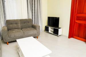 uma sala de estar com um sofá e uma televisão em The vacation em Kigali