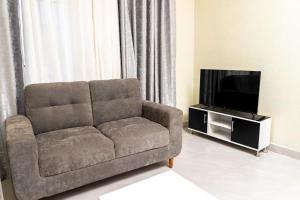 a living room with a couch and a flat screen tv at The vacation in Kigali