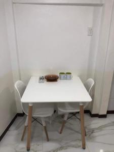 uma mesa branca e cadeiras com duas chávenas em Jirah’s inn em Legazpi