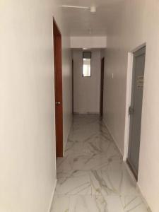 an empty hallway with marble floors and a door at Jirah’s inn in Legazpi