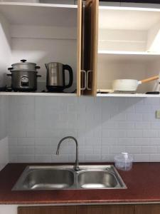 um balcão de cozinha com um lavatório na cozinha em Jirah’s inn em Legazpi