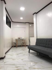 uma sala de estar com um sofá e uma mesa em Jirah’s inn em Legazpi