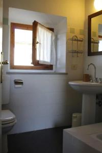 ein Bad mit einem WC, einem Waschbecken und einem Fenster in der Unterkunft Podere Massoli in San Casciano in Val di Pesa