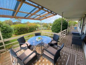 un patio con tavolo e sedie su un ponte di Parnella Cottage - Pet friendly a St Helens