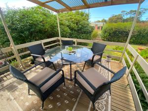 a patio with a table and chairs on a deck at Parnella Cottage - Pet friendly in St Helens