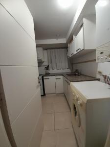 a small kitchen with white cabinets and a dishwasher at Depto Martinez in Tandil +2 photos