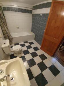 a bathroom with a black and white checkered floor at Hotel Paris Ltda. in Santiago
