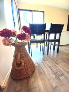 un jarrón con flores en una habitación con sillas en Cabaña Encantos del Mar, en Cáhuil