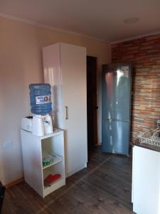 a kitchen with a refrigerator and a shelf with a refrigerator at Cabaña Encantos del Mar in Cáhuil