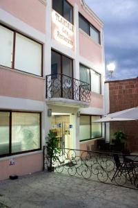 Tlaxcala de Xicohténcatl的住宿－Hotel Tlaxcala，带阳台的建筑,前面设有长椅