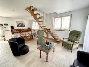 ein Wohnzimmer mit einer Treppe, einem Tisch und Stühlen in der Unterkunft Maison Jullouville, 3 pièces, 6 personnes - FR-1-361-464 in Jullouville-les-Pins