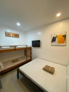 a bedroom with two bunk beds and a television at Ati Lodge Boracay in Boracay