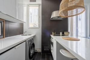 Il comprend une cuisine équipée d'un évier et d'un lave-linge. dans l'établissement Grand studio- Design & Cosy, à Charenton-le-Pont