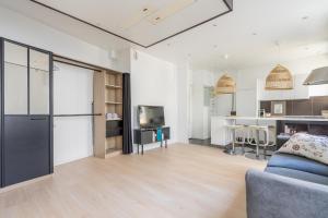 Il comprend un salon avec un canapé et une cuisine. dans l'établissement Grand studio- Design & Cosy, à Charenton-le-Pont