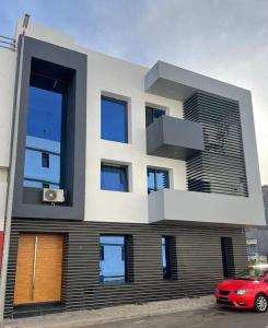 a house with a red car parked in front of it at Apto T0 na Capital in Praia