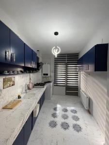 a kitchen with blue cabinets and a white tile floor at Çanakkale centre & tourism in Çanakkale